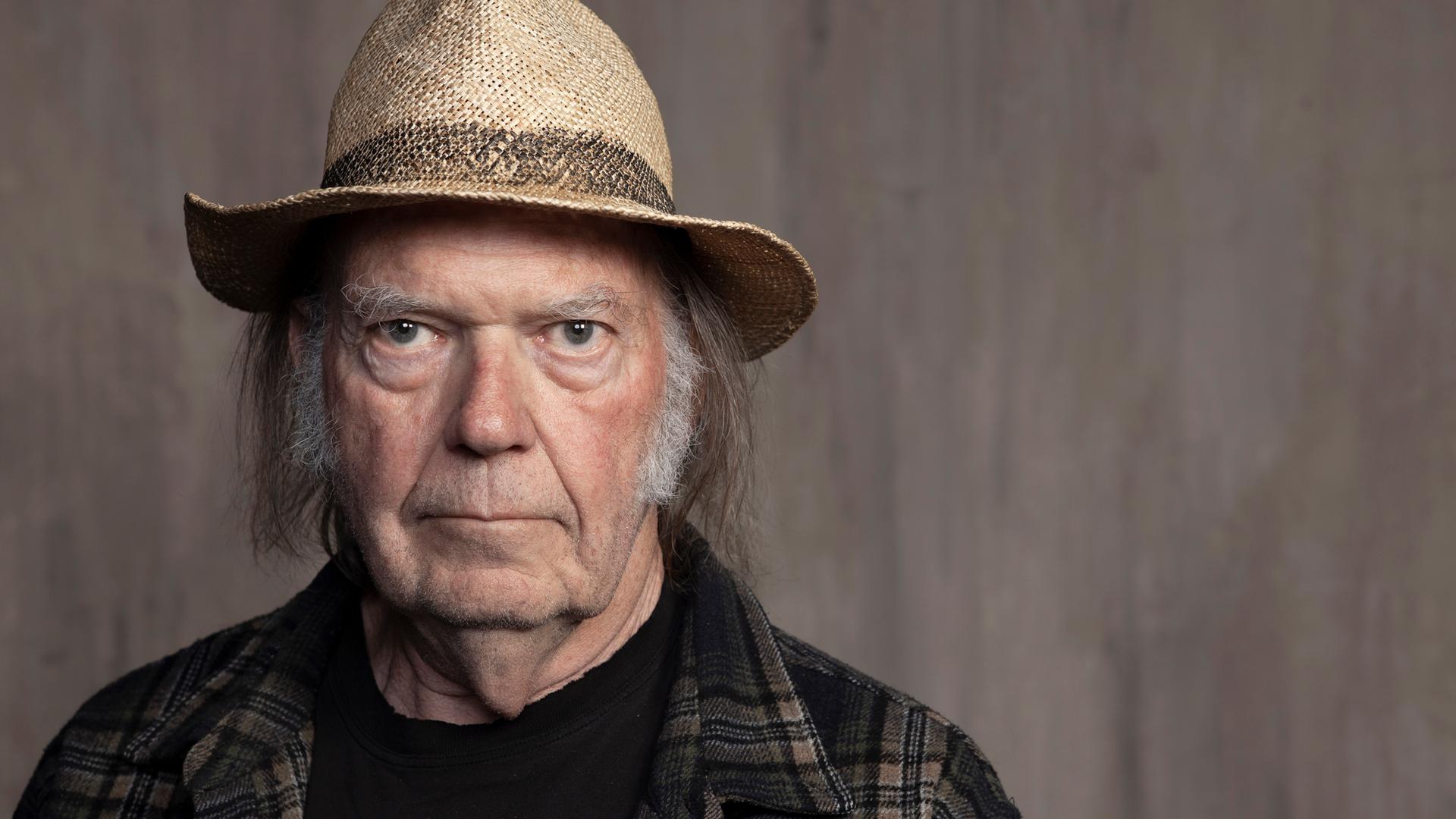 Neil Young posiert mit Hut und Flannellhemd. Neil Young posiert mit Hut und Flannellhemd.