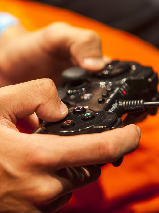 Symbolbild für die Gefahren für Jugendliche bei der unbeaufsichtigten Internetnutzung: Ein Heranwachsender hat den Controller eines Videospiels in der Hand. 