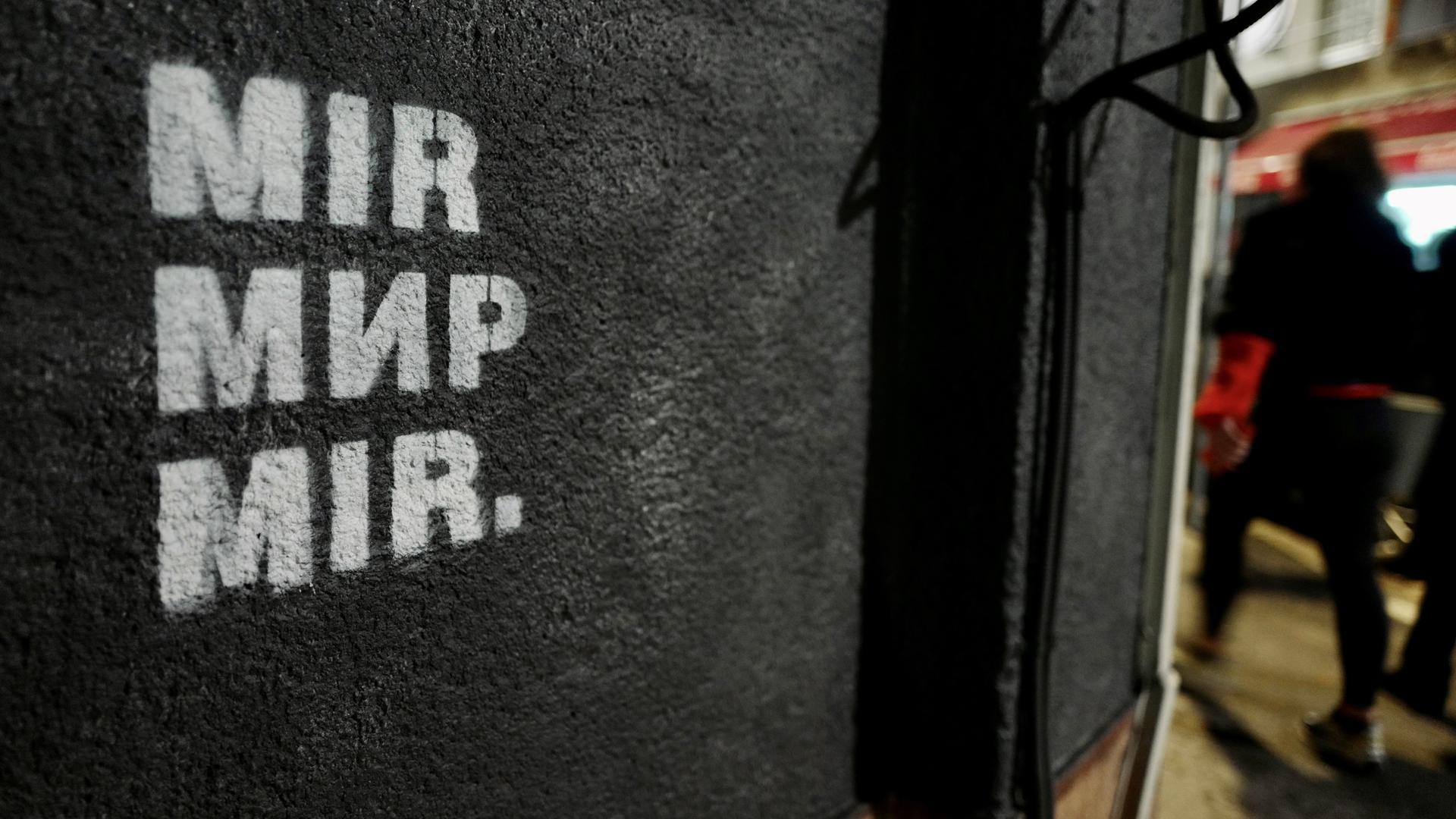 An einer schwarzen Hauswand steht in weißer Schrift "Mir", das Wort für Frieden in drei Sprachen: Bosnisch, Kroatisch, Serbisch. An einer schwarzen Hauswand steht in weißer Schrift "Mir", das Wort für Frieden in drei Sprachen: Bosnisch, Kroatisch, Serbisch.