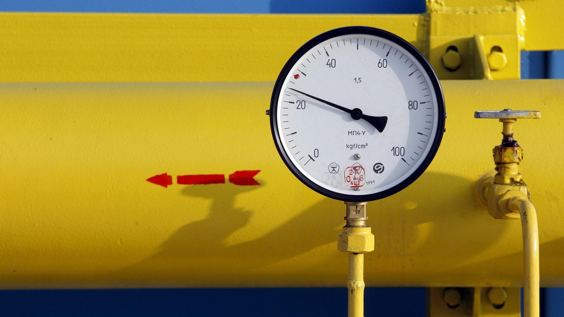 Das Bild zeigt ein Gasdruckmessgerät der neuen Gasverdichterstation "Bobrovnytska" im Dorf Mryn. Im Hintergrund ist eine gelbe Gasleiting zu sehen, mit einem roten Pfeil, der nach links zeigt.
