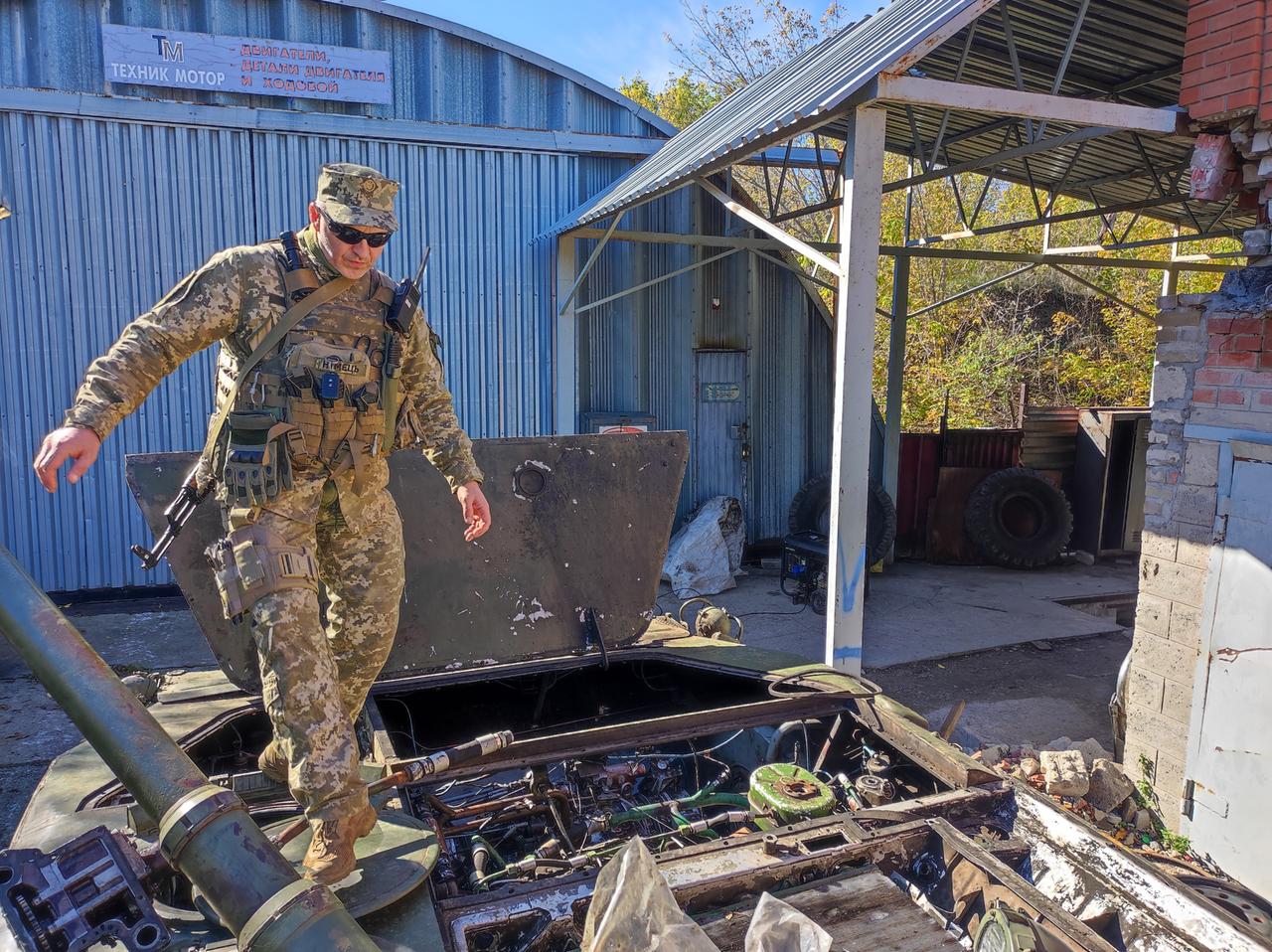Ein ukrainischer Soldat läuft auf einem zerstörten russischen Panzer herum. Ein ukrainischer Soldat läuft auf einem zerstörten russischen Panzer herum.