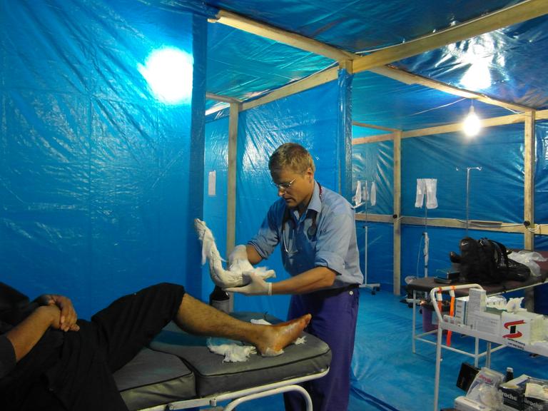 Ein Arzt von "Ärzte ohne Grenzen" behandelt einen Patienten in einem medinizinischen Behelfszelt. 