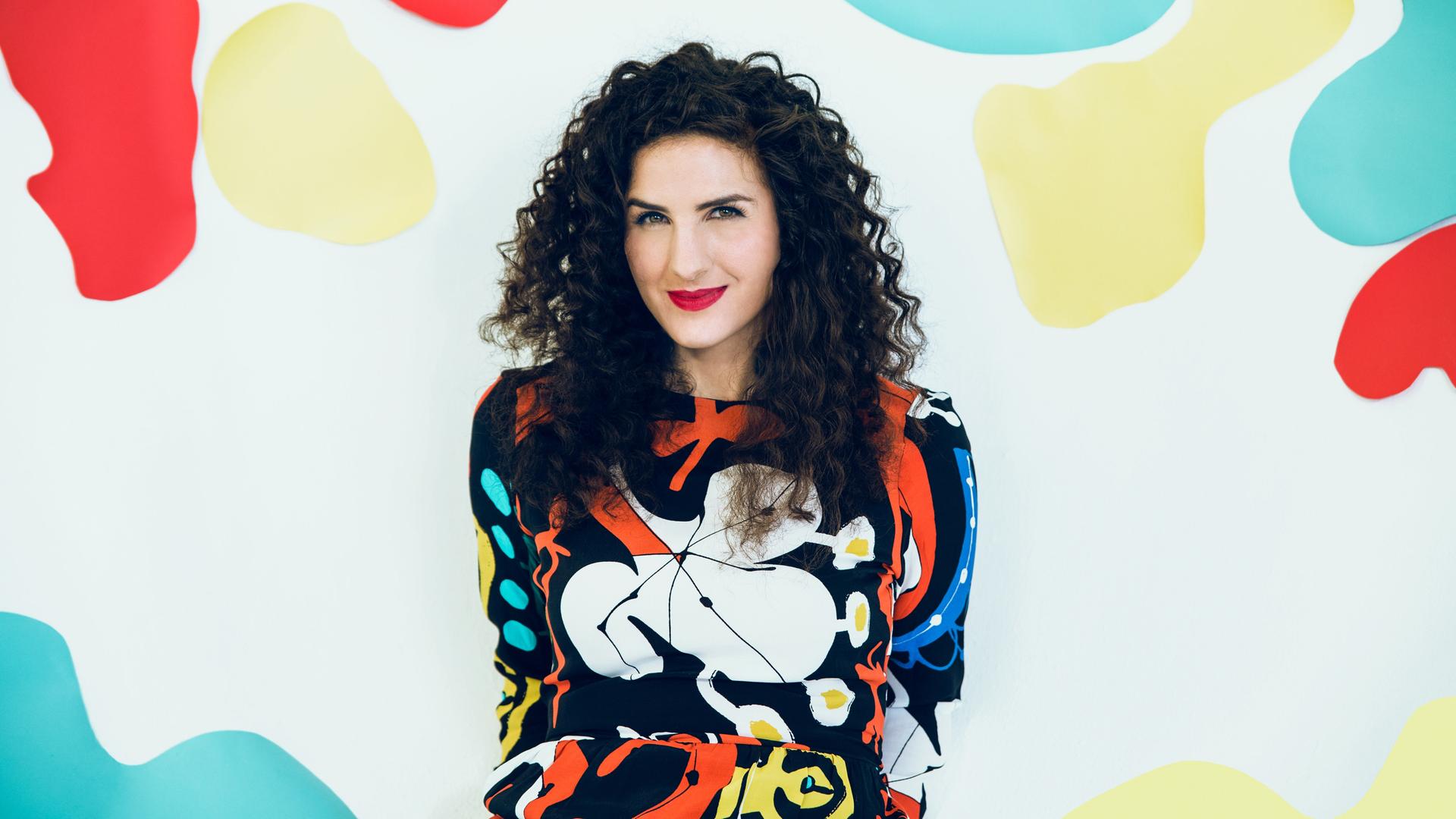 Auf dem Bild ist die kanadische Sängerin und Pianistin Laila Biali zu sehen. Sie lächelt in die Kamera und trägt einen bunten Pullover. Auf dem Bild ist die kanadische Sängerin und Pianistin Laila Biali zu sehen. Sie lächelt in die Kamera und trägt einen bunten Pullover.
