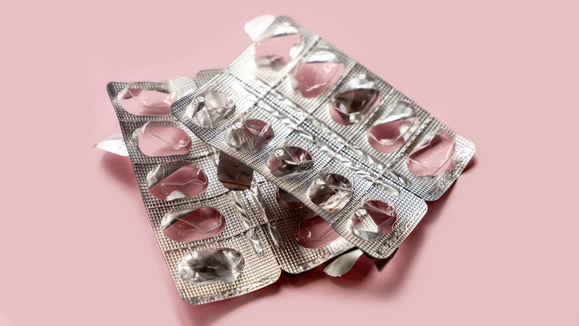Eine leere Medikamentenpackung auf einem rosa Hintergrund.