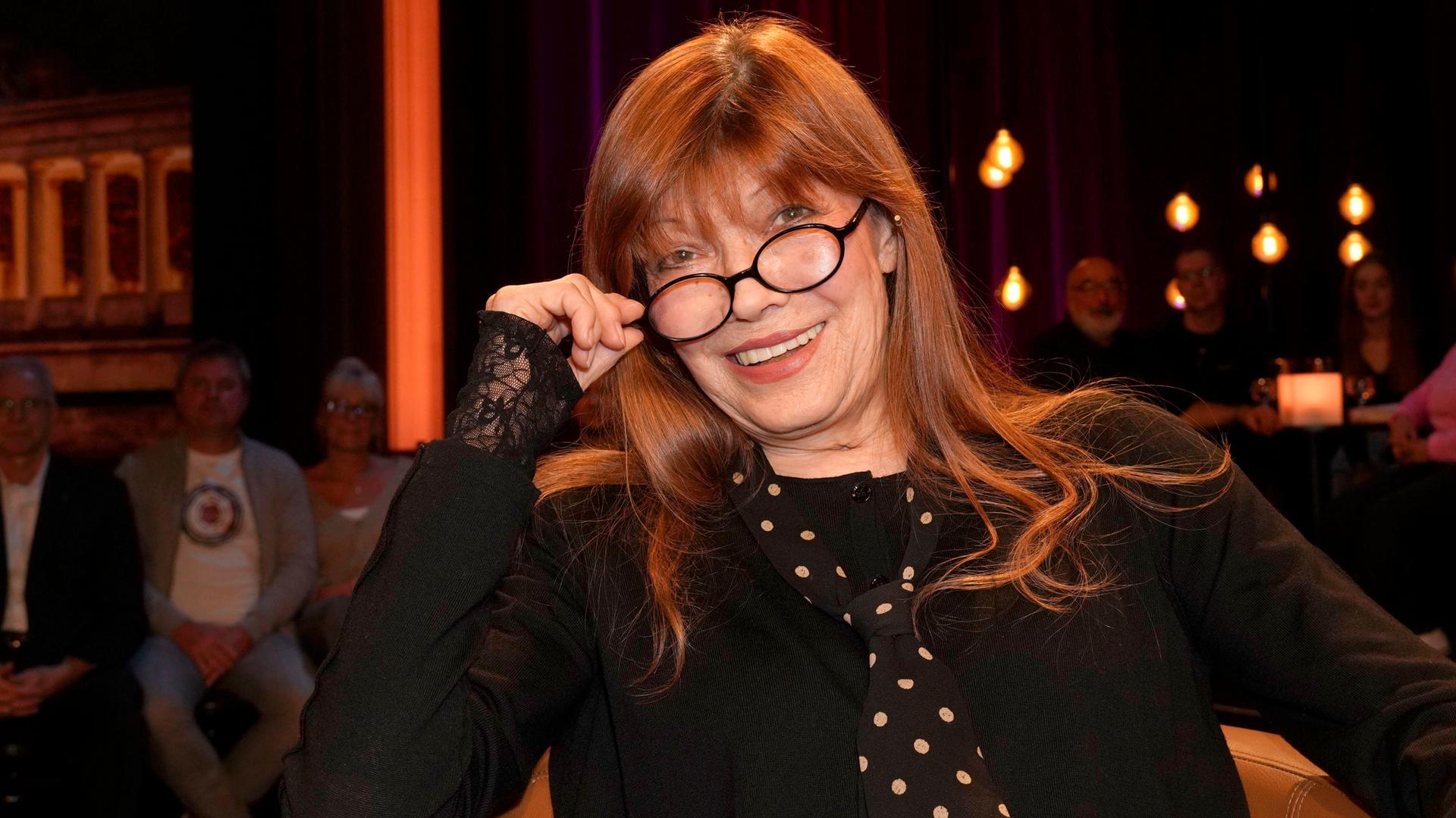 Die Sängerin und Schauspielerin Katja Ebstein schaut über den Rand ihrer Brille und lächelt in die Kamera. Die Sängerin und Schauspielerin Katja Ebstein schaut über den Rand ihrer Brille und lächelt in die Kamera.
