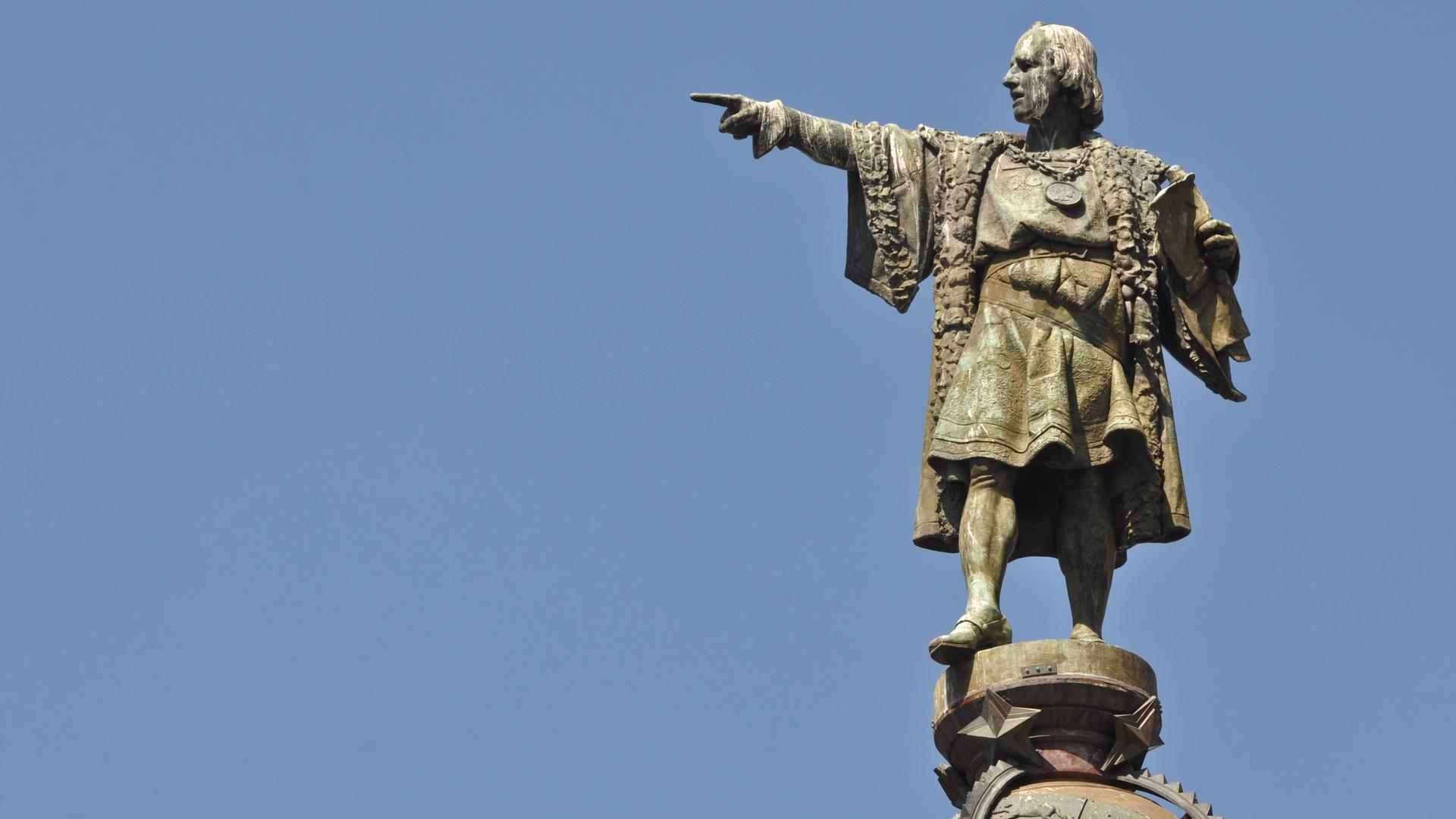 Auf dem Bild ist eine Statue von Christoph Kolumbus zu sehen, wie sie nach Westen zeigt. 