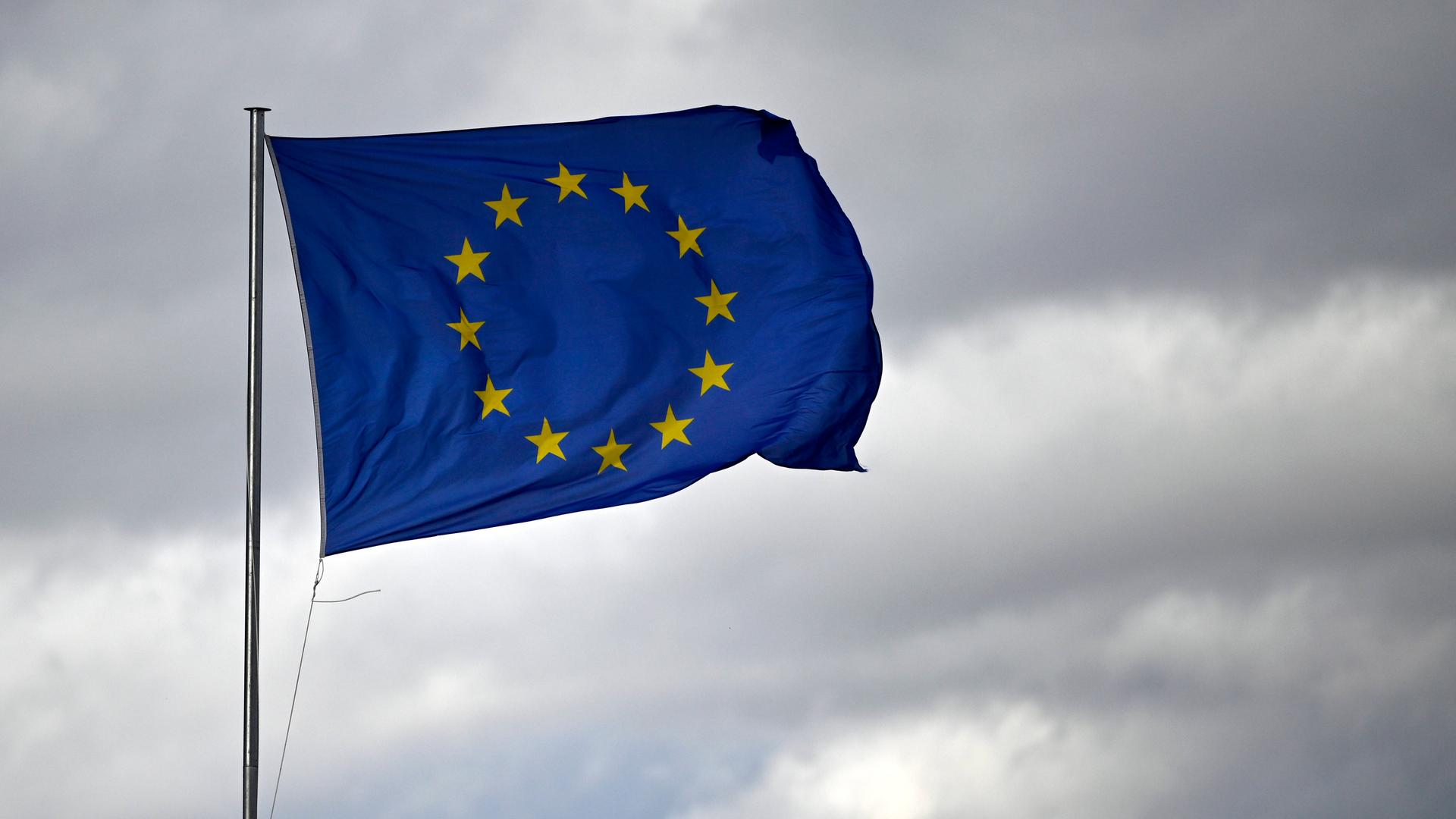 Eine EU-Flagge im Wind vor bewölktem Himmel 