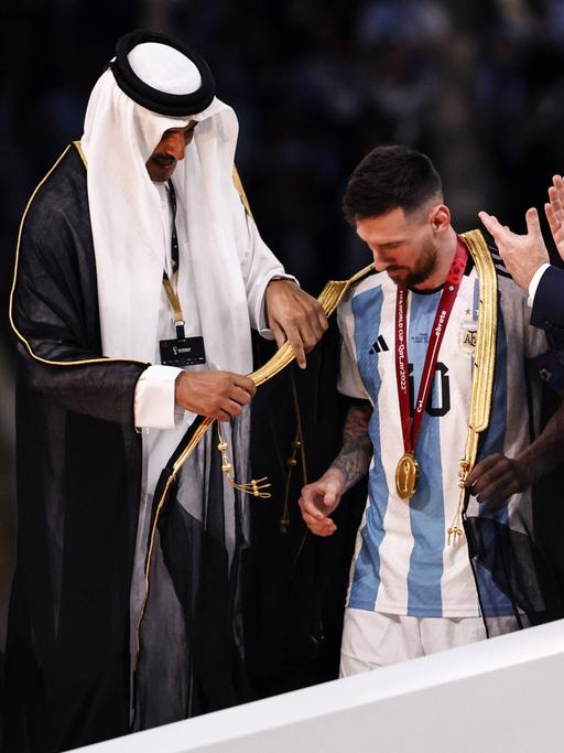 Der Emir von Katar legt Lionel Messi bei der Siegerehrung ein Gewand um.