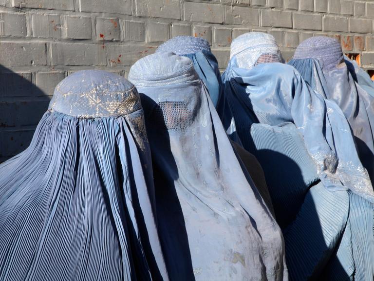 Mehrere Frauen in Afghanistan sind komplett mit blauen Gewändern verhüllt. 