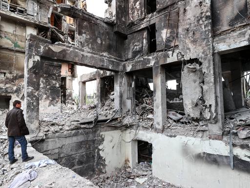 Ein Mann in Mariupol in den Ruinen eines zerstörten Hauses. 