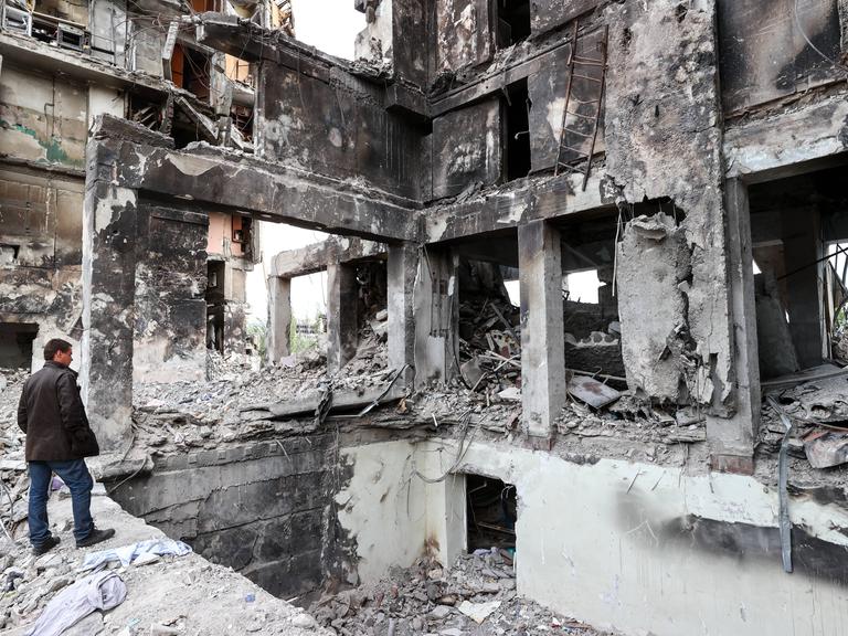 Ein Mann in Mariupol in den Ruinen eines zerstörten Hauses. 