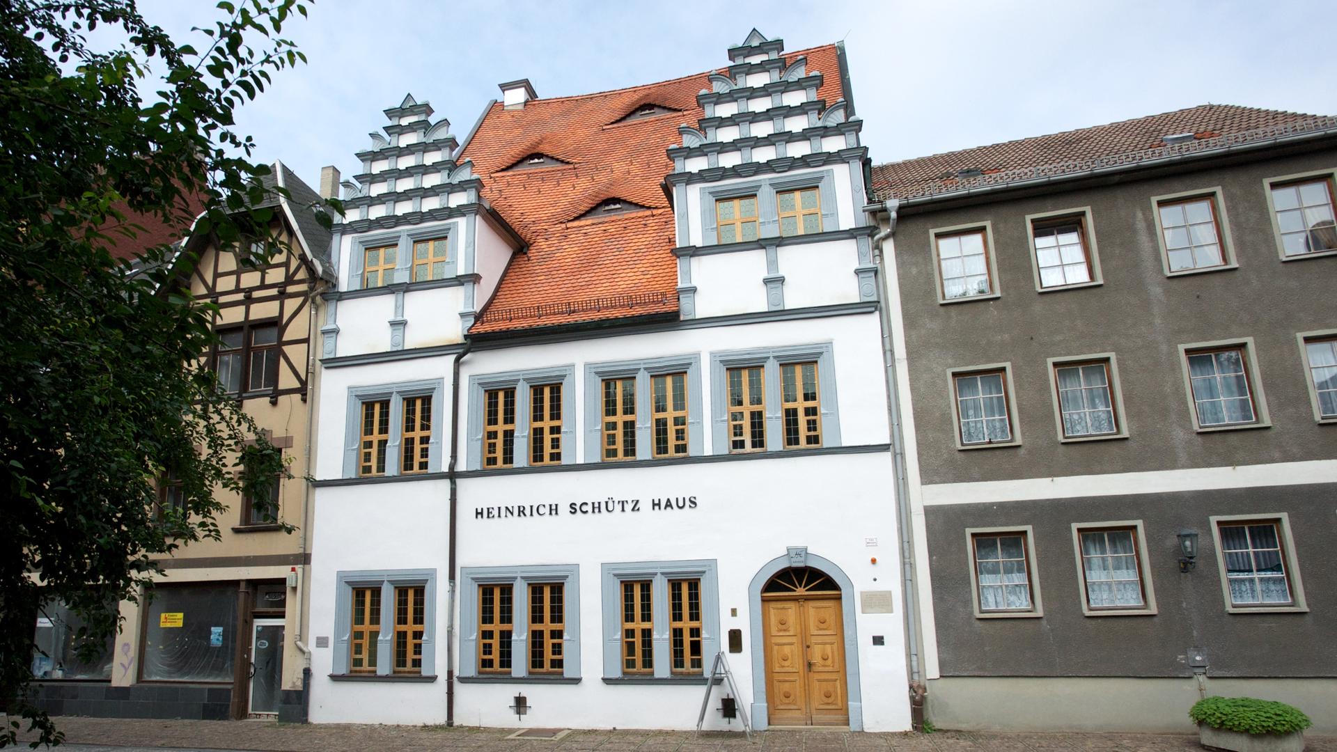Blick auf das weiß-graue Heinrich Schütz Haus, das mit seinen besonderen Fassadenaufbauten punktet.