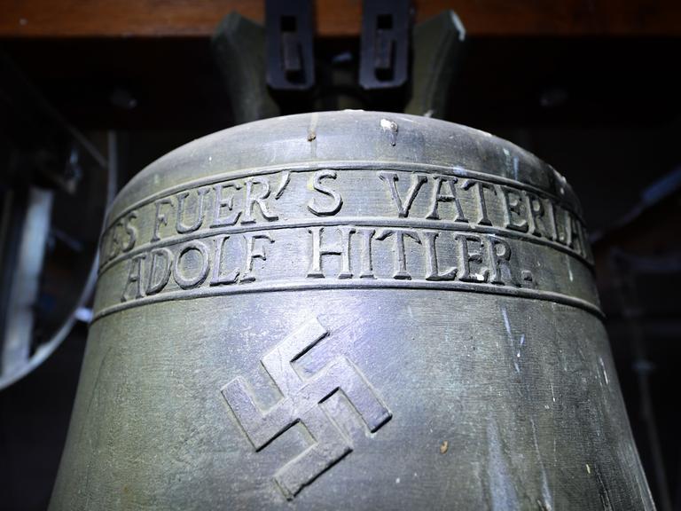 Eine Bronzeglocke mit Hakenkreuz und dem Spruch "Alles fürs Vaterland - Adolf Hitler"
