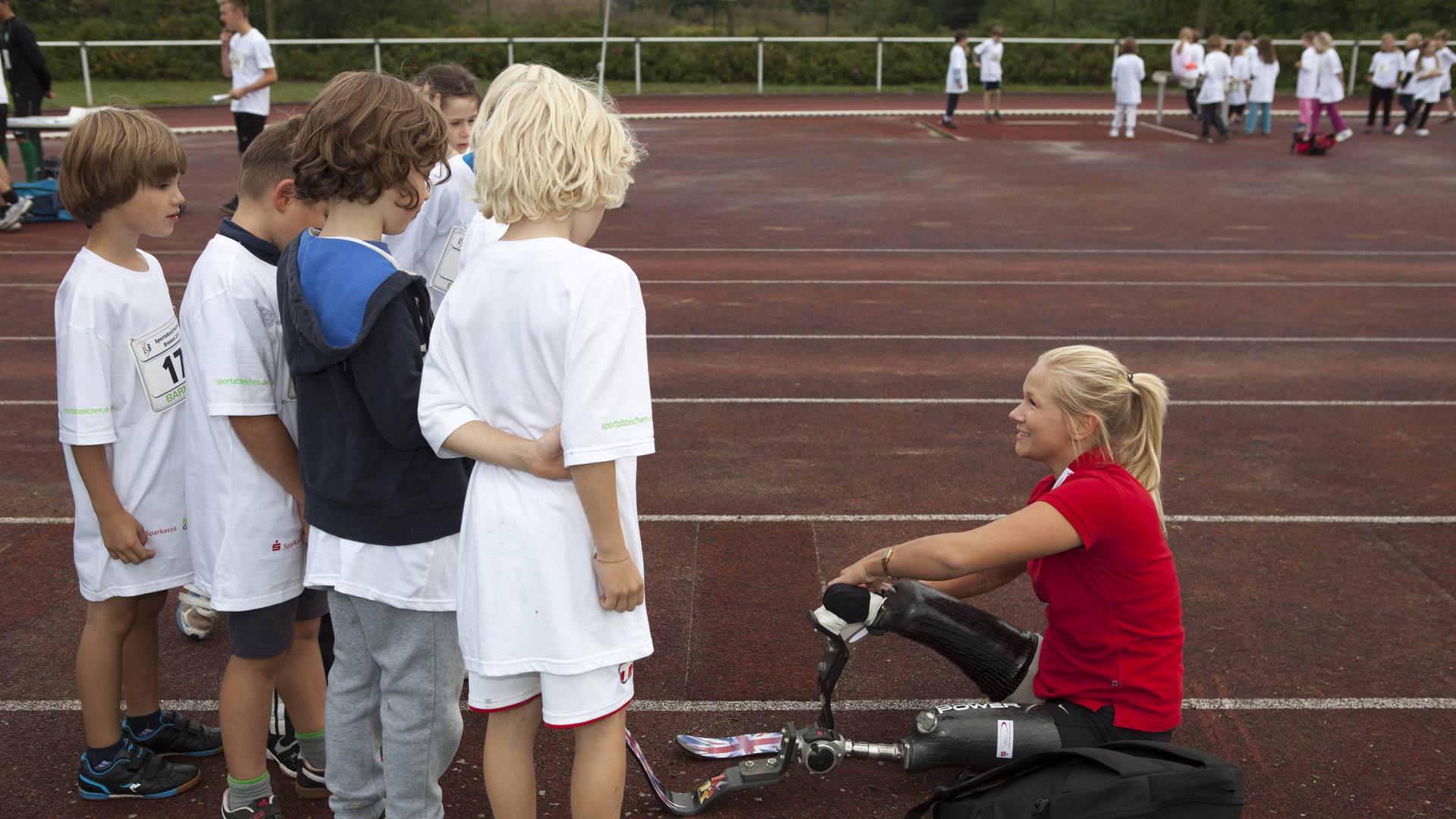 Vanessa Low ( Paralympische Weltmeisterin im Weitsprung ) mit Kindern auf einer Laufbahn Bildnummer: 14471211