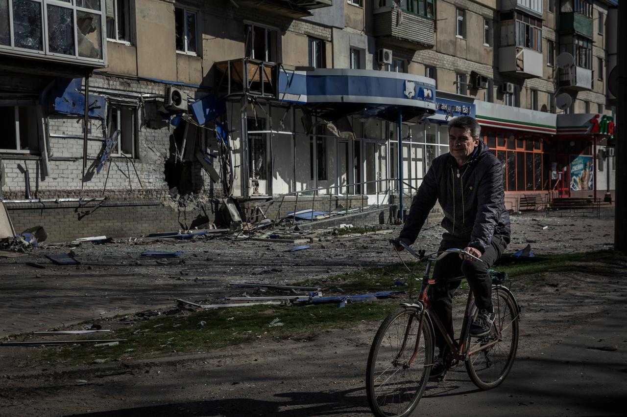 Sjewjerodonezk: Ein Mann fährt mit einem Fahrrad an einem Wohnhaus vorbei, das durch einen früheren russischen Angriff beschädigt wurde. Sjewjerodonezk: Ein Mann fährt mit einem Fahrrad an einem Wohnhaus vorbei, das durch einen früheren russischen Angriff beschädigt wurde.