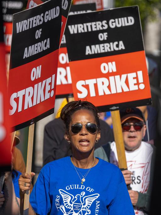 Mehrere Personen tragen Schilder mit der Aufschrift "Writers Guild of America on Strike"