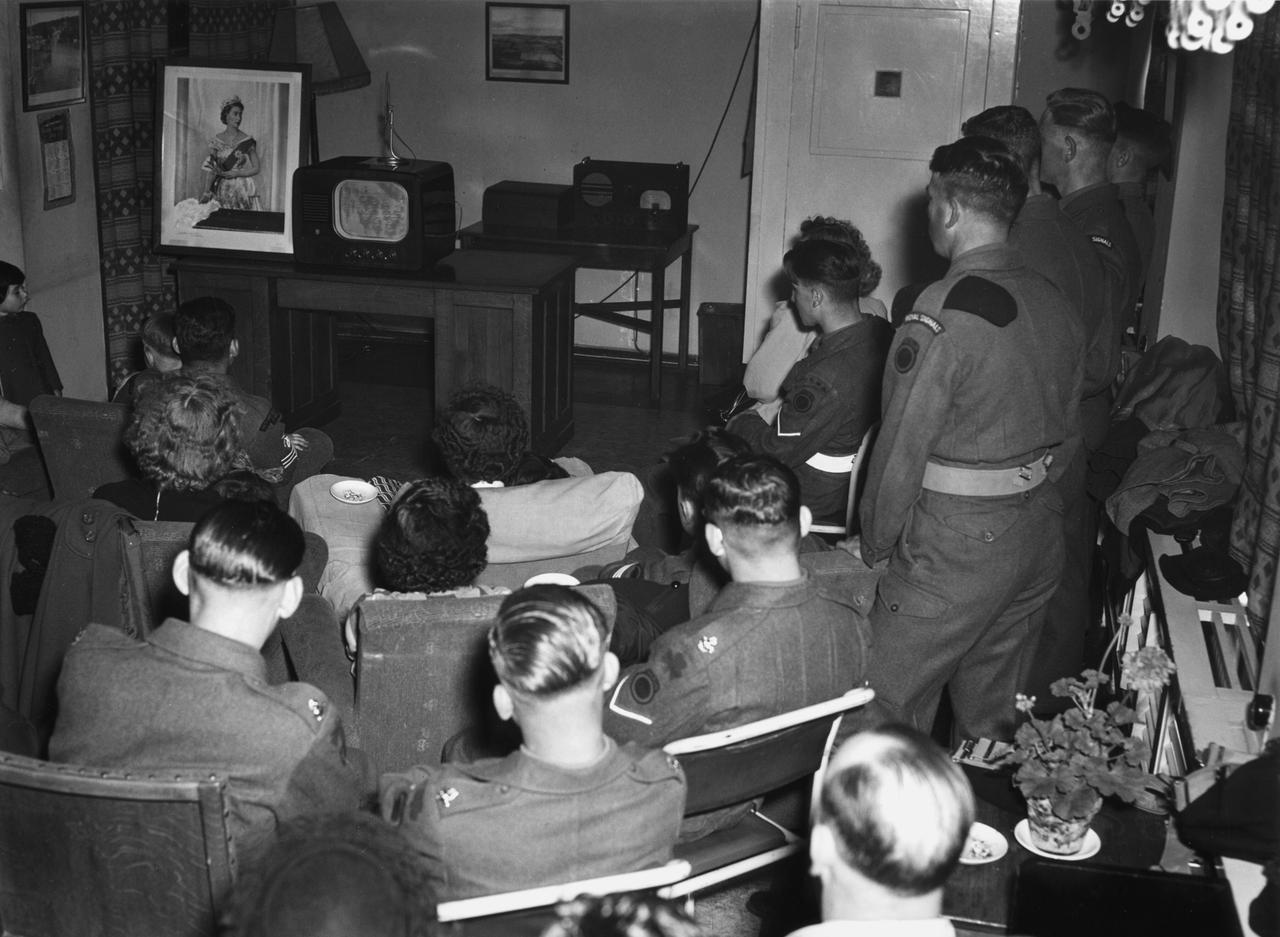 Soldaten verfolgen auf einem kleinen Fernseher live die Krönung Elizabeths II. im Sommer 1953. Soldaten verfolgen auf einem kleinen Fernseher live die Krönung Elizabeths II. im Sommer 1953.