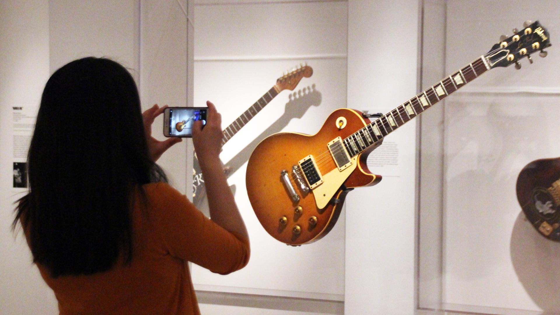 Eine Besucherin des Metropolitan Museum in New York fotografiert die ausgestellte Gibson-Gitarre von Jimmy Page. Eine Besucherin des Metropolitan Museum in New York fotografiert die ausgestellte Gibson-Gitarre von Jimmy Page.