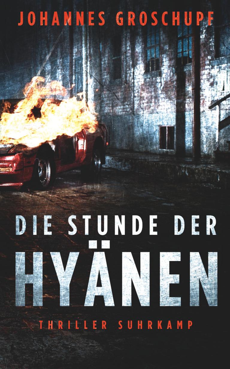 Das Buchcover des Krimis von Johannes Groschupf, "Die Stunde der Hyänen". Es zeigt ein rotes, brennendes Auto auf einer schmuddeligen Straße bei Nacht, im Hintergrund ist ein Backsteingebäude im Fabrikstil zu erkennen. Das Buch ist auf der Krimibestenliste von Deutschlandfunk Kultur. Das Buchcover des Krimis von Johannes Groschupf, "Die Stunde der Hyänen". Es zeigt ein rotes, brennendes Auto auf einer schmuddeligen Straße bei Nacht, im Hintergrund ist ein Backsteingebäude im Fabrikstil zu erkennen. Das Buch ist auf der Krimibestenliste von Deutschlandfunk Kultur.