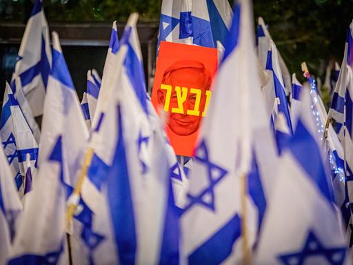 Hunderttausende Menschen demonstrieren im April gegen Netanjahus Pläne zur Reform des Justizwesens. Zwischen blau-weißen Israel-Flaggen ist ein Plakat mit dem Konterfei Netanjahus zu sehen auf dem auf Hebräisch "Unfähigkeit" steht. 