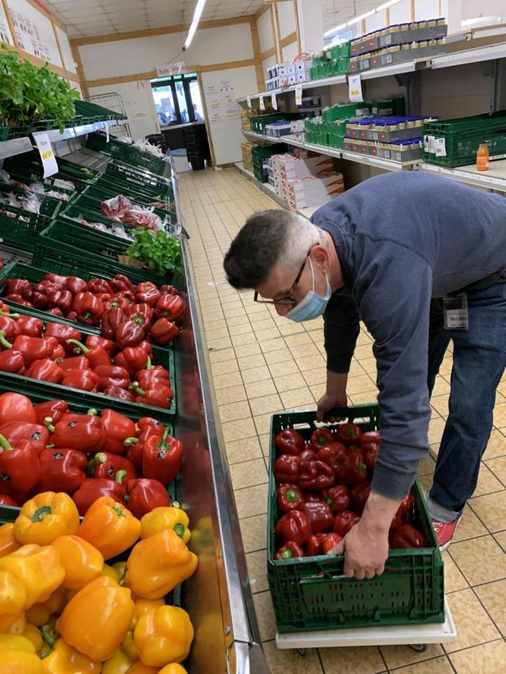 Ein Mitarbeiter der Tafel Stuttgart-Mitte räumt Paprika in die Auslage. Im Vodergrund ist gelbes und rotes Paprika zu sehen. Ein Mitarbeiter der Tafel Stuttgart-Mitte räumt Paprika in die Auslage. Im Vodergrund ist gelbes und rotes Paprika zu sehen.