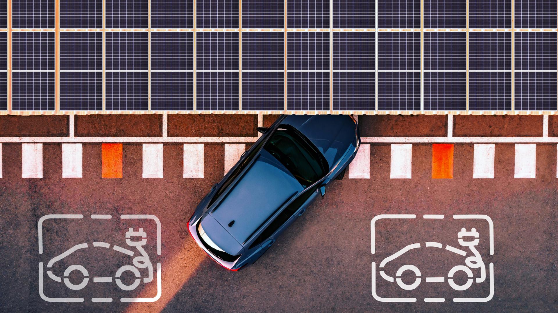 Ein Elektroauto fährt an eine Ladestation heran, die von Solarzellen überdacht ist. Die Aufnahme ist aus der Luft entstanden. Ein Elektroauto fährt an eine Ladestation heran, die von Solarzellen überdacht ist. Die Aufnahme ist aus der Luft entstanden.