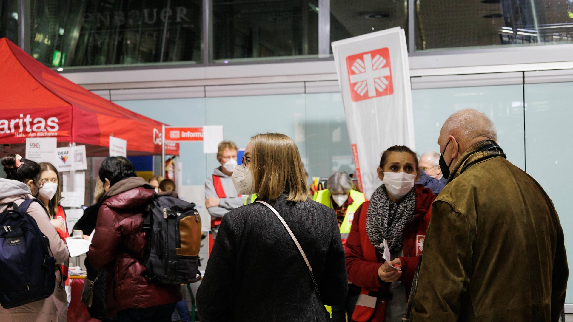 An einem Caritas-Stand in München stehen Mitarbeiter und Laufpublikum. An einem Caritas-Stand in München stehen Mitarbeiter und Laufpublikum.