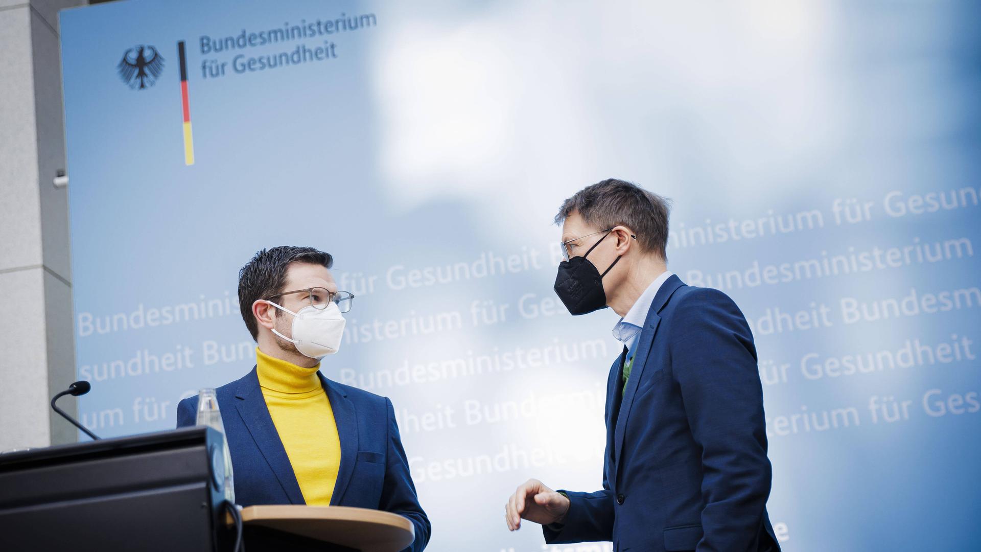 Bundesgesundheitsminister Karl Lauterbach und Bundesjustizminister Marco Buschmann sprechen mit einander, beide tragen einen Mund-Nasen-Schutz.