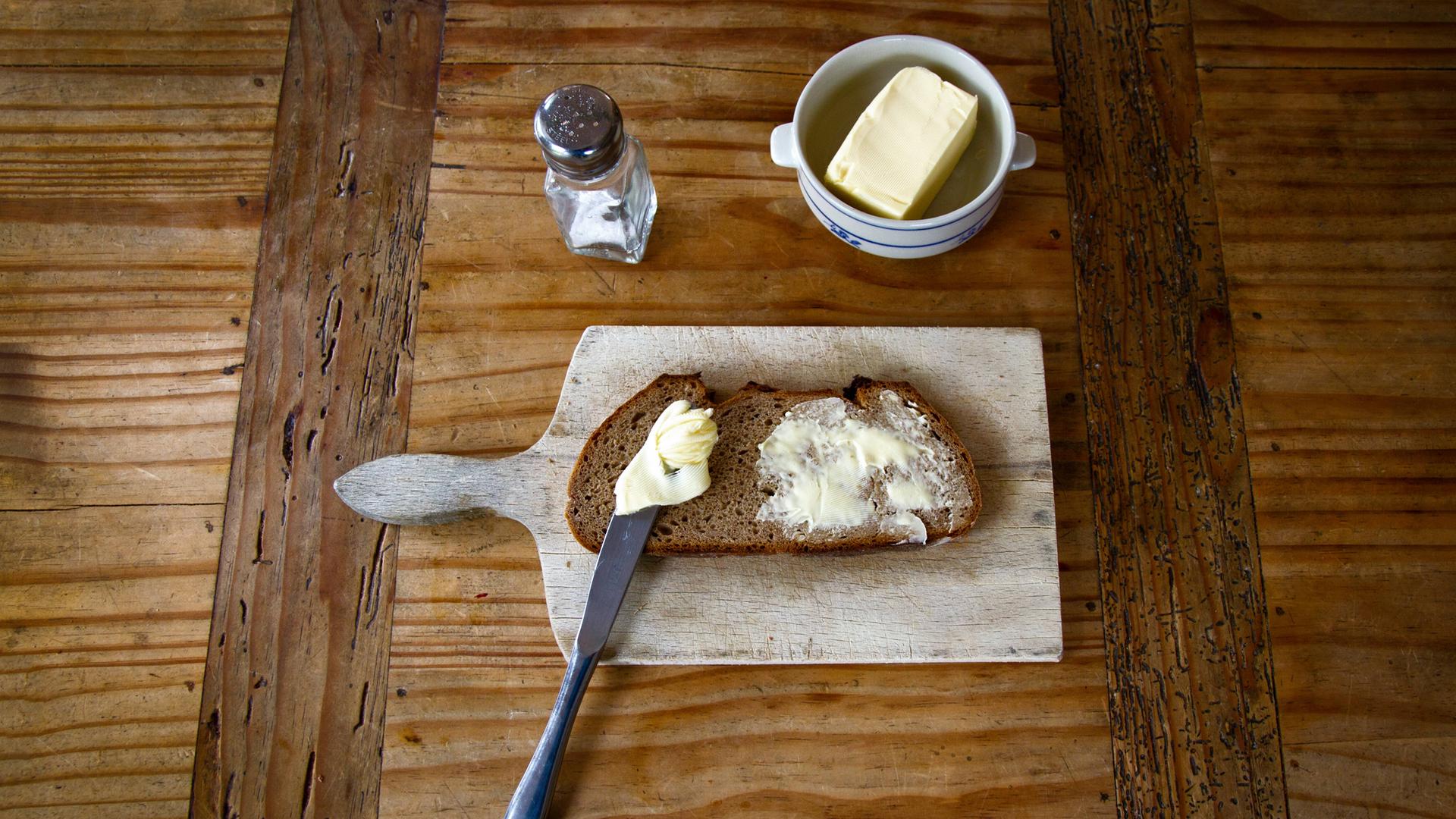 Salz, Butter und Brot auf einem Brettchen. Salz, Butter und Brot auf einem Brettchen.