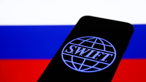 SWIFT-Logo auf einem Smartphone vor russischer Flagge