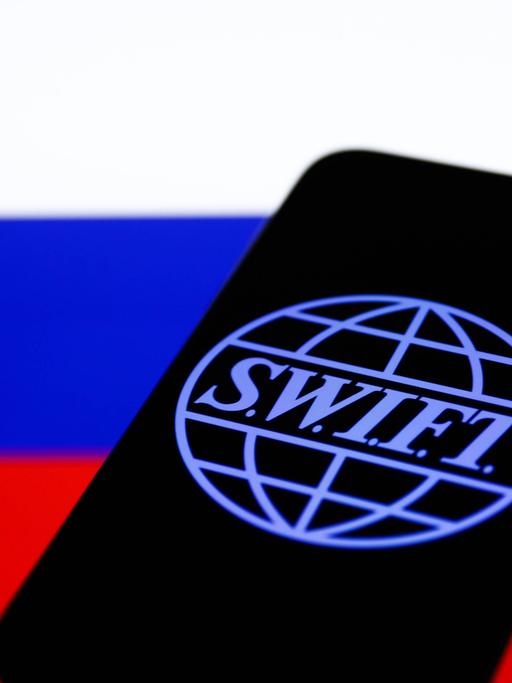 SWIFT-Logo auf einem Smartphone vor russischer Flagge