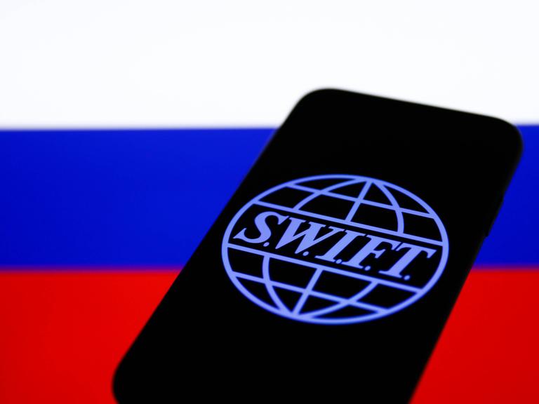 SWIFT-Logo auf einem Smartphone vor russischer Flagge