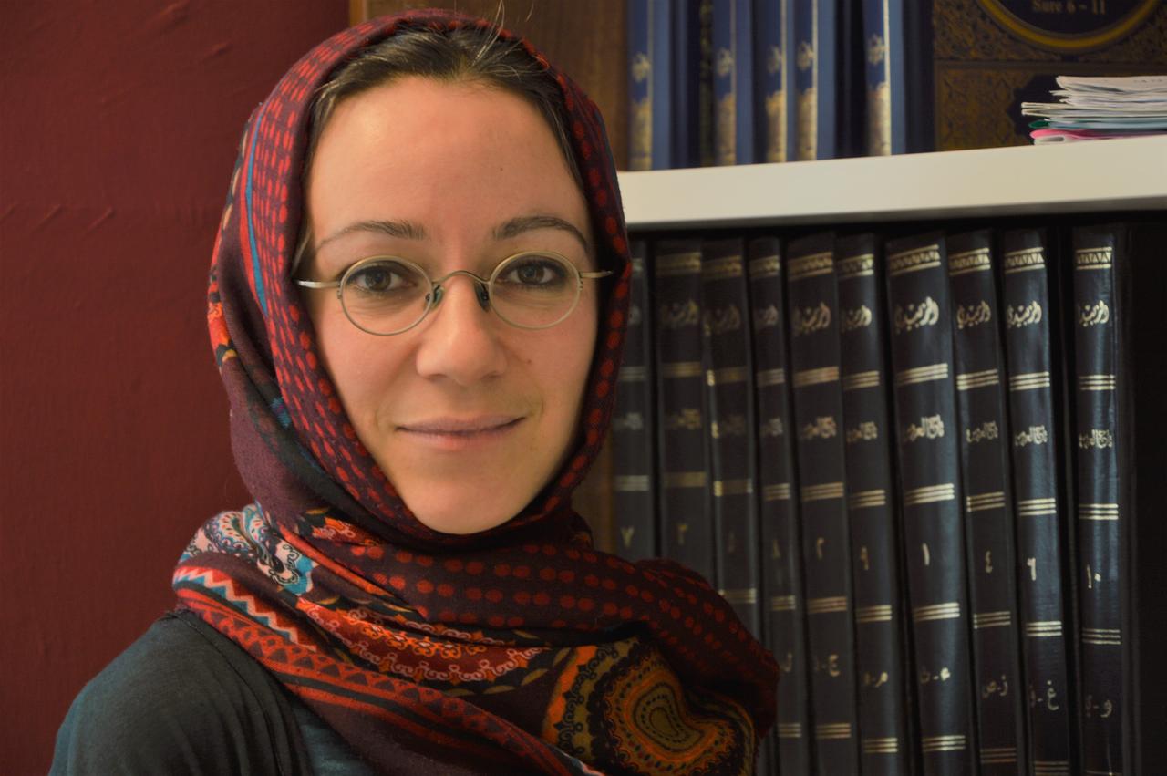 Porträt der islamischen Theologin Muna Tatari vor einer Bücherwand. Porträt der islamischen Theologin Muna Tatari vor einer Bücherwand.