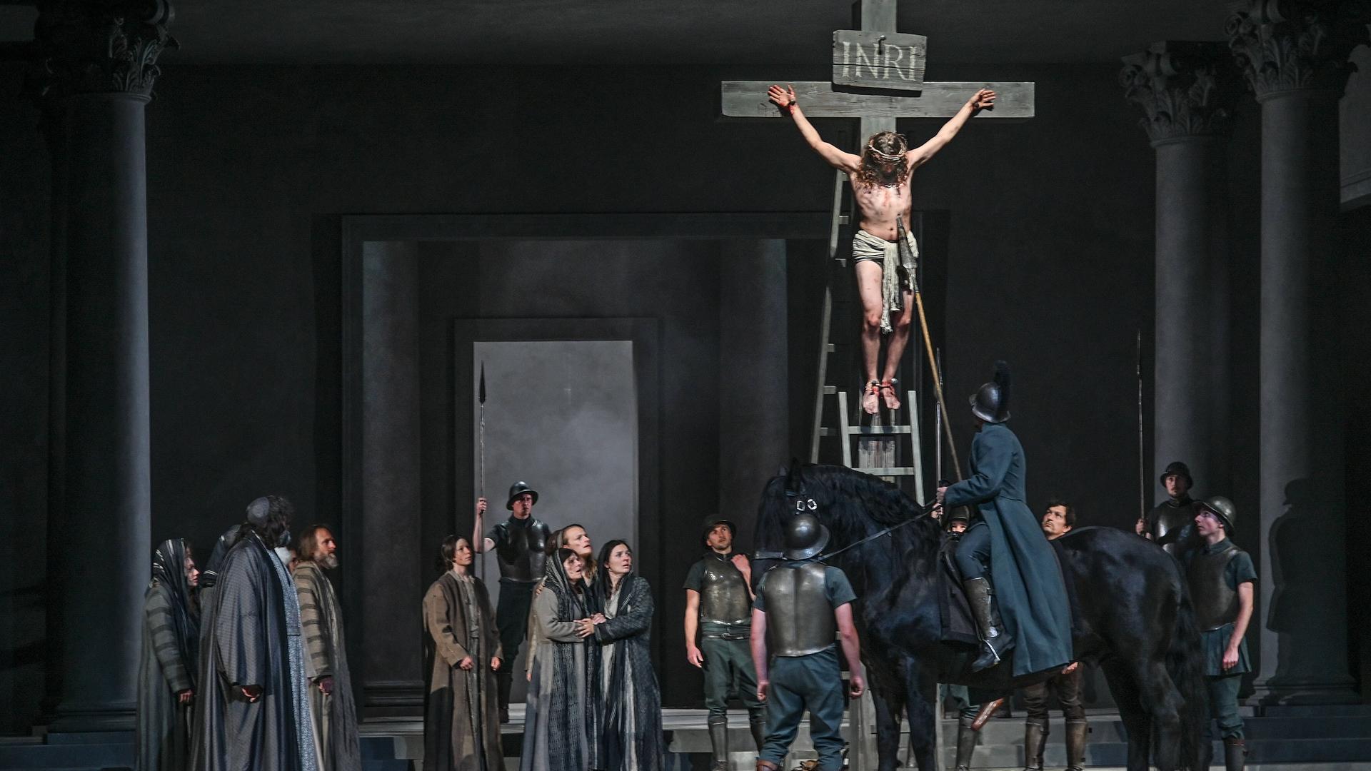 Bei der Fotoprobe zu den 42. Oberammergauer Passionsspiele sind rund zwei Dutzend Menschen auf der Bühne. Jesus hängt am Kreuz, ein römischer Soldat sticht mit einer Lanze in Jesu Brust.
