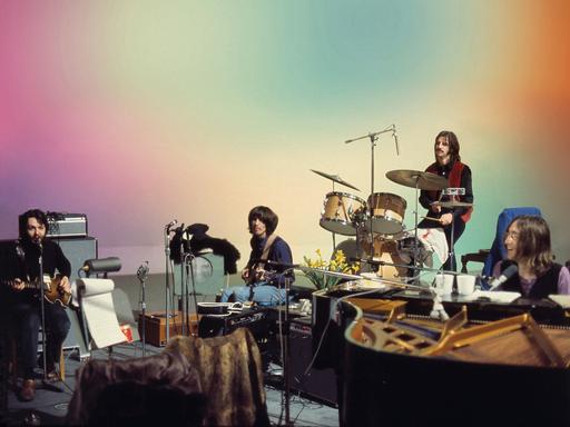 Paul McCartney, George Harrison, Ringo Starr und John Lennon an ihren Instrumenten.