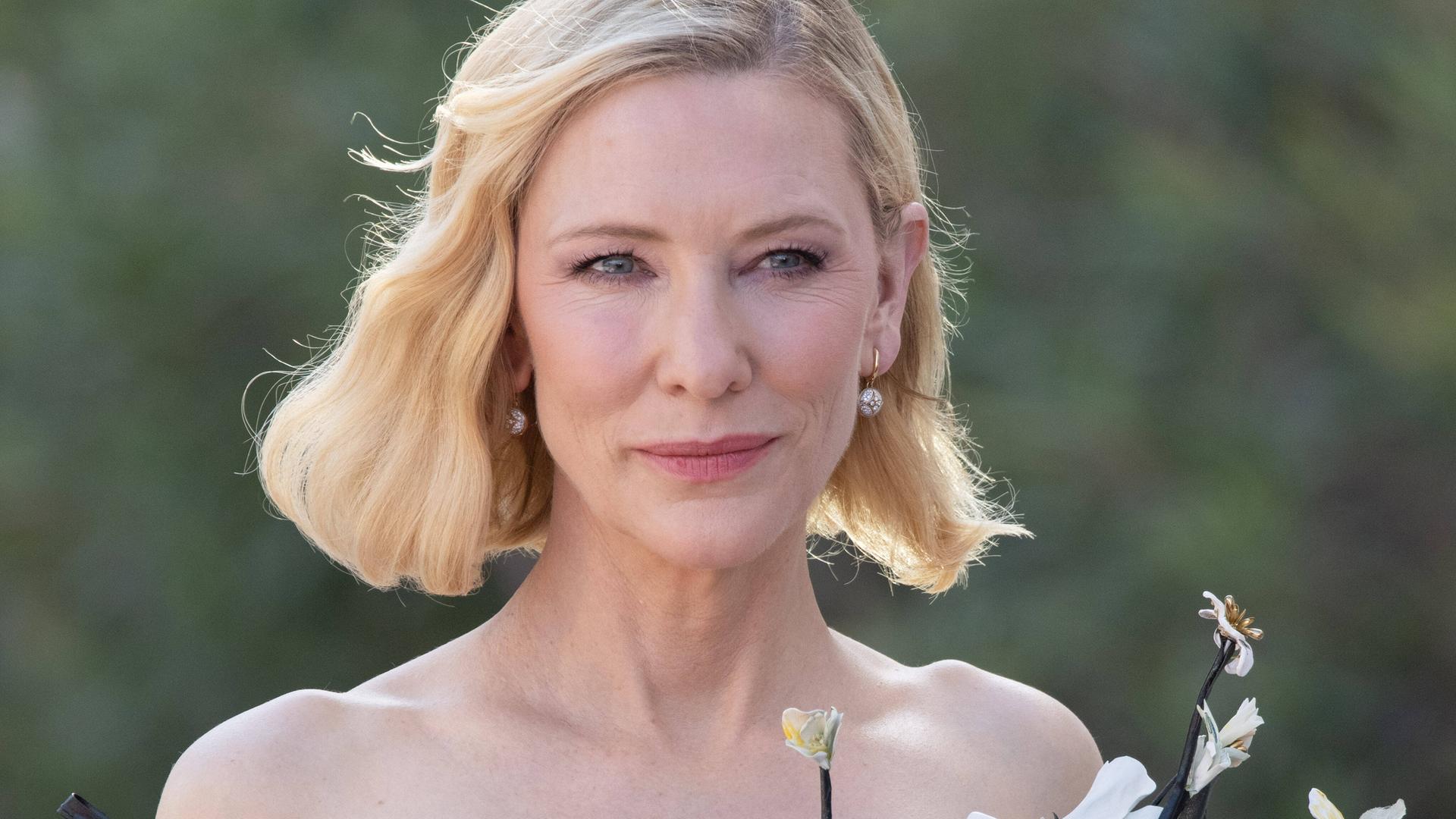Cate Blanchett steht in einer grünen Landschaft und lächelt. Cate Blanchett steht in einer grünen Landschaft und lächelt.