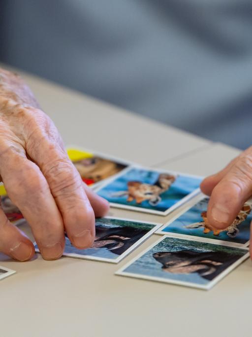 Eine Bewohnerin des Altenheims Maria Eich spielt auf einer Pflegestation das Spiel "Memory" und legt Kartenpaare zusammen.