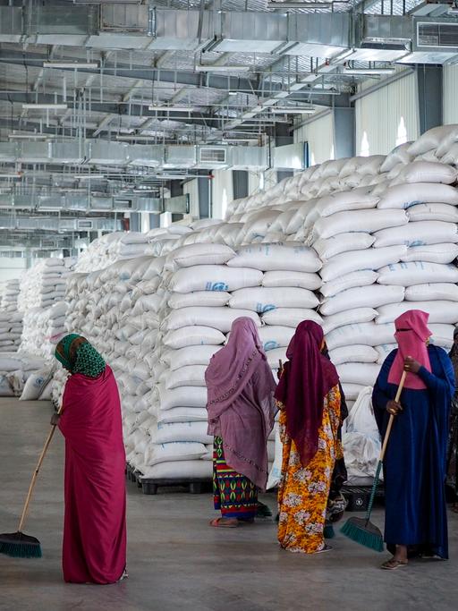 FILE - Workers clean the floor as sacks of food earmarked for the Tigray and Afar regions sits in piles in a warehouse of the World Food Programme (WFP) in Semera, the regional capital for the Afar region, in Ethiopia on Feb. 21, 2022. The aid agency Oxfam International warned Tuesday, March 22, 2022 that widespread hunger across East Africa could become "a catastrophe" without an injection of funds to the region's most vulnerable communities. (AP Photo, File)