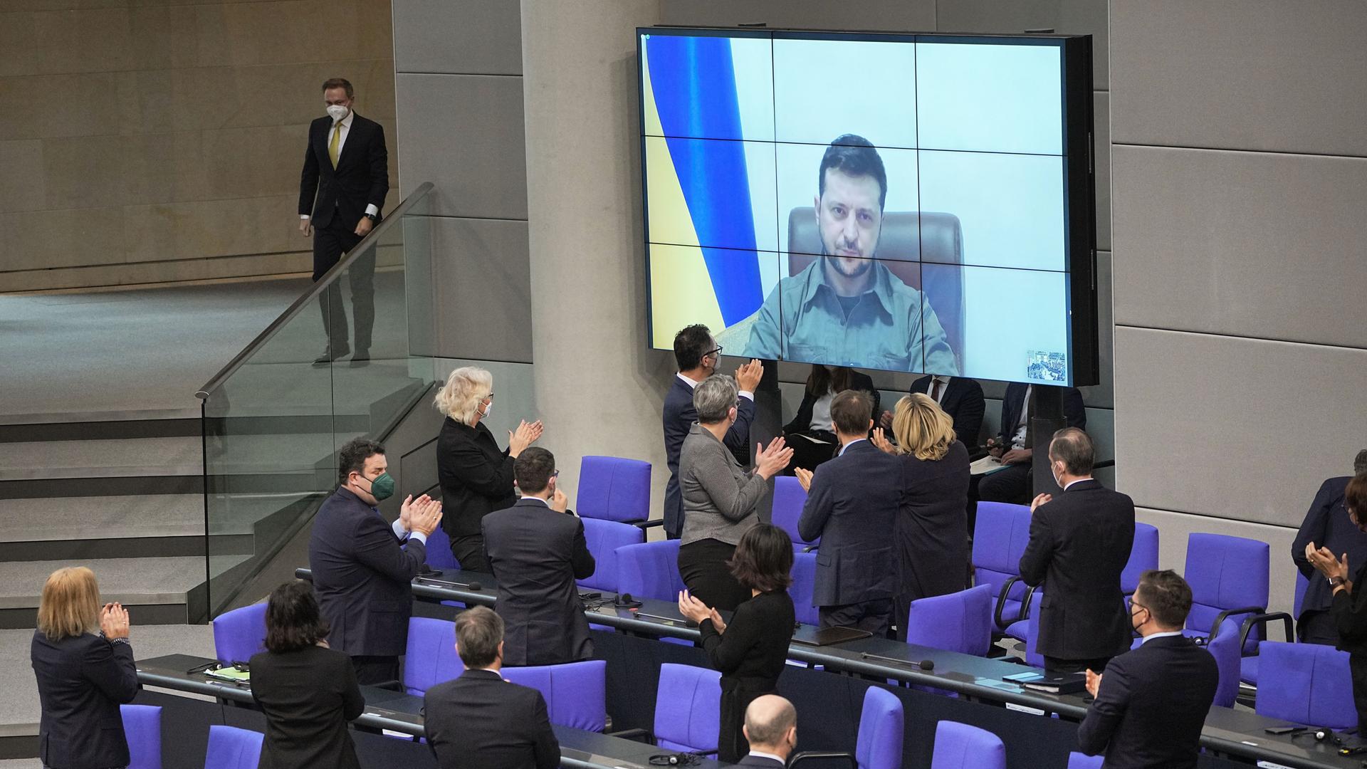 Der ukrainische Präsident Wolodymyr Selenskyj spricht auf einer Videoleinwand im Bundestag und bekommt Applaus von der Bundesregierung. Der ukrainische Präsident Wolodymyr Selenskyj spricht auf einer Videoleinwand im Bundestag und bekommt Applaus von der Bundesregierung.