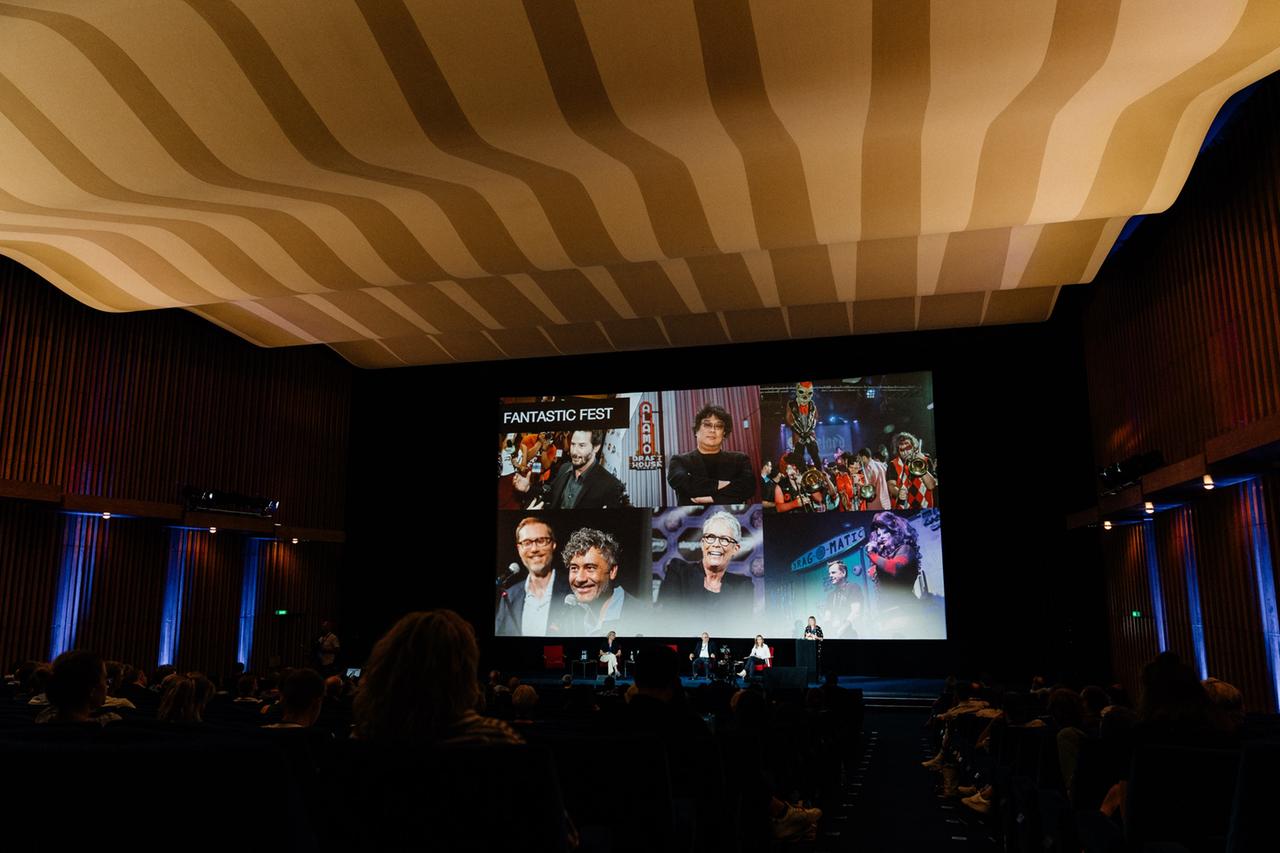 Podiumsdiskussion im Kino International, Berlin. Auf der Leinwand sind verschiedene Künstler aus der internationalen Kino-Szene zu sehen. Podiumsdiskussion im Kino International, Berlin. Auf der Leinwand sind verschiedene Künstler aus der internationalen Kino-Szene zu sehen.