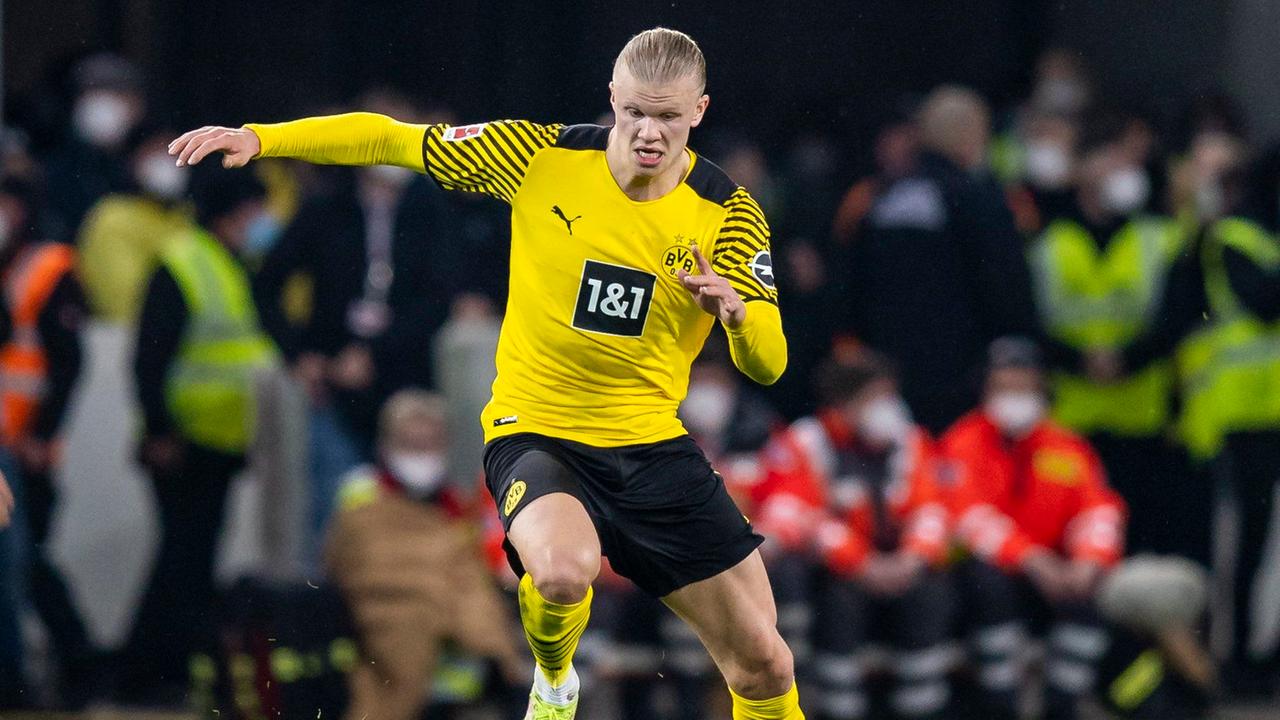 Ein Fußballspieler läuft mit einem Ball am Fuß. Ein Fußballspieler läuft mit einem Ball am Fuß.