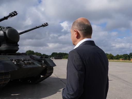 Bundeskanzler Olaf Scholz (SPD) besucht das Ausbildungsprogramm für ukrainische Soldaten an dem Flugabwehrkanonenpanzer Gepard und steht vor einem Gepard Panzer
