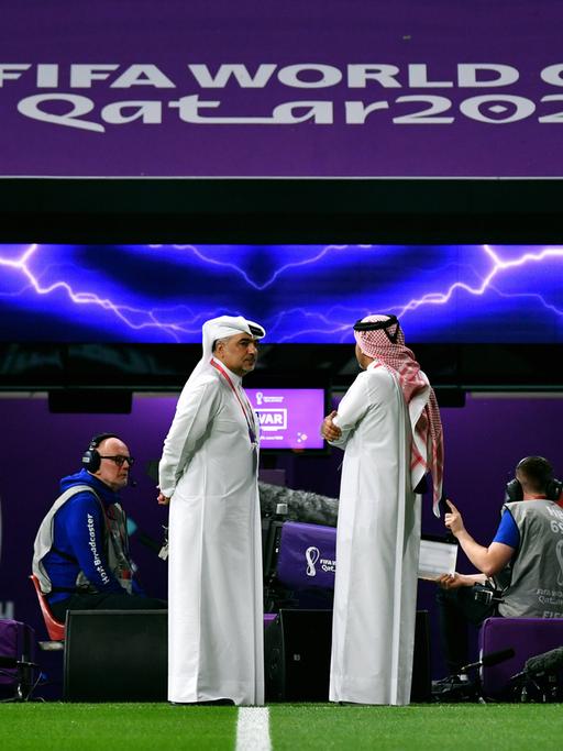 Zwei katarische Offizielle in traditionellem Thawb bei der Fußball-WM 2022 in Katar.