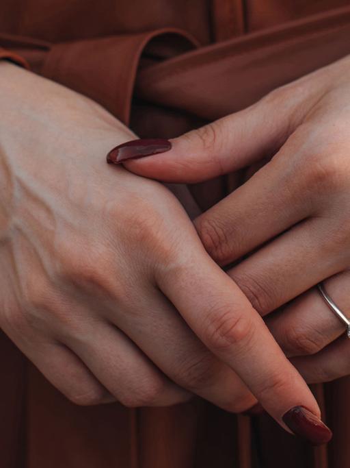 Hab und Gier - eine rabenschwarze Komödie, ein Poker um Testamente, Geld und Leben. Zu sehen: Die Hände einer Frau mit langen roten Fingernägeln und einem kleinen Ring am rechten Ringfinger.