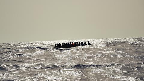 Ein Holzboot mit etwa 30 Menschen versucht bei hohem Wellengang die gefährliche Überfahrt nach Italien.