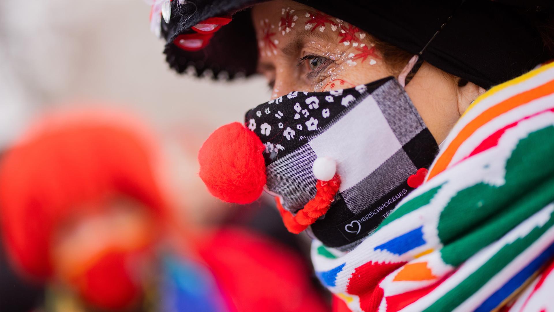 Eine Karnevalistin in Köln feiert mit medizinischer Maske und Kostüm beim Auftakt der Karnevalssession auf dem Heumarkt