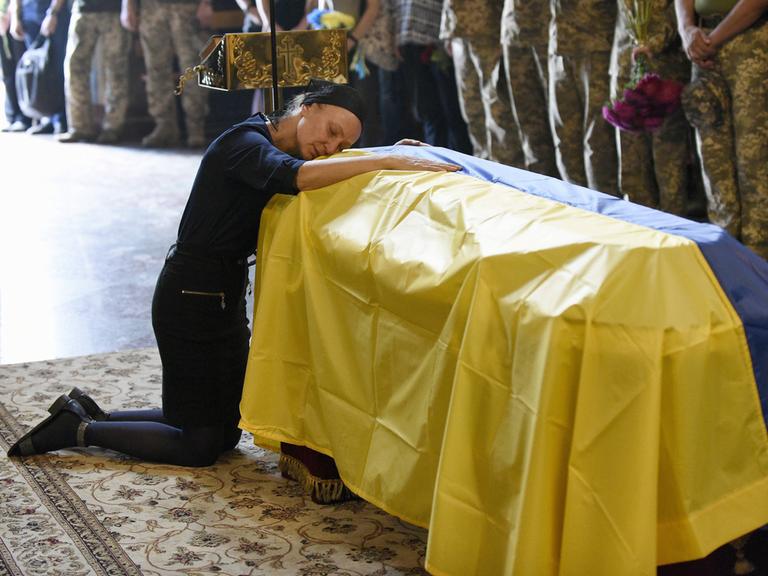 Beerdigung des ukrainischen Soldaten Roman Barvinok im Agust in Kiew. Eine Mutter trauert am Sarg um ihren Sohn. 