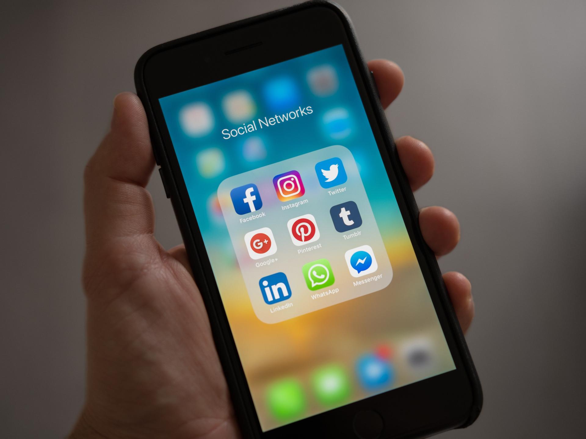 Auf einem Smartphone-Display sind verschiedene Social Apps zu sehen wie Instagram, Facebook und Pinterest.