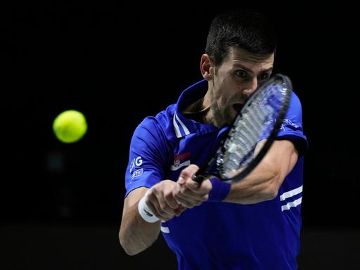 Das Bild zeigt den Tennis-Profi Novak Djokovic. Er schlägt eine Rückhand