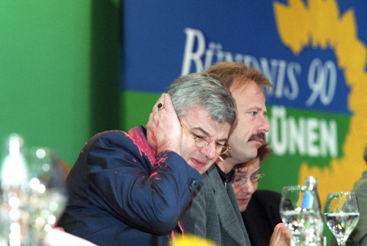 Von einem Farbbeutel getroffen, fasst sich der damalige Bundesaußenminister Joschka Fischer am 13.05.1999 auf dem Sonderparteitag der Grünen in Bielefeld erschrocken ans Ohr. 
